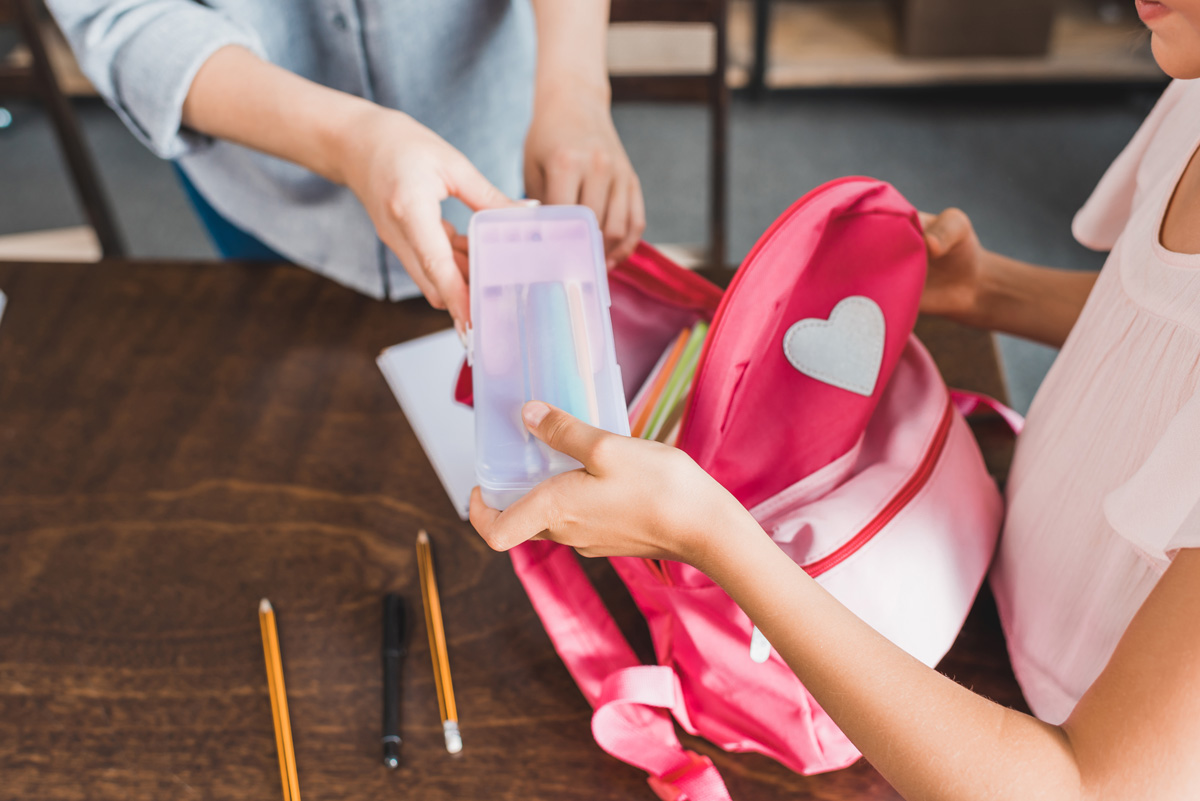 student putting items in bag
