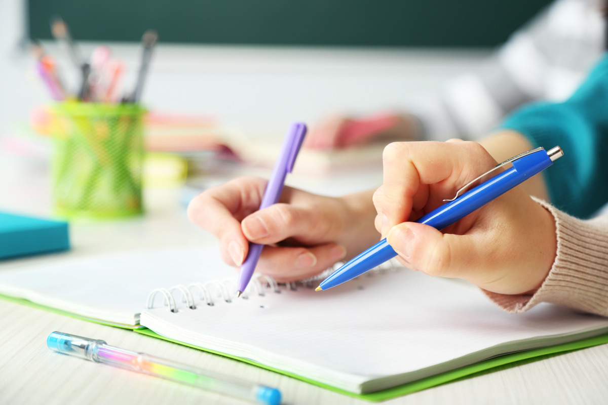 two hands holding pens
